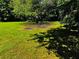 Lush backyard featuring a concrete pad and mature trees providing ample shade at 208 Arbour Way, Suwanee, GA 30024