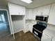 Modern kitchen features white cabinets, stainless steel appliances, and sleek countertops, open to dining area at 208 Arbour Way, Suwanee, GA 30024