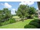 View of lush backyard with green lawn, trees and black fence overlooking the community golf course at 214 Misty View Dr, Canton, GA 30114