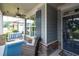 Covered front porch with porch swing, ceiling fan, seating, and stone pillars near the front door at 214 Misty View Dr, Canton, GA 30114