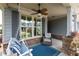 Relaxing porch area with a swing, ceiling fan, accent chair, and stone pillar accents at 214 Misty View Dr, Canton, GA 30114