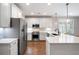 Well-lit kitchen with stainless steel appliances, white cabinets, and quartz countertops at 214 Misty View Dr, Canton, GA 30114