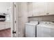 Bright laundry room featuring a white washer and dryer, white cabinets, and ample storage at 214 Misty View Dr, Canton, GA 30114