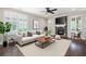 Stylish living room featuring a stone fireplace, ceiling fan, and abundant natural light at 214 Misty View Dr, Canton, GA 30114