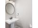 Stylish powder room with a pedestal sink, decorative mirror, and modern lighting at 214 Misty View Dr, Canton, GA 30114