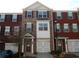 Brick townhome featuring a front-entry garage, white trim, and symmetrical window design at 2199 Landing Walk Dr, Duluth, GA 30097