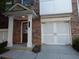 Townhome exterior showcasing brick facade, covered porch, and garage at 2199 Landing Walk Dr, Duluth, GA 30097