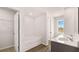 Bright bathroom features a bathtub, double sink vanity with bright countertops, and wood style floor at 321 Sound Cir, Stockbridge, GA 30281