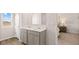 Bright bathroom with double sink vanity, wood style floors, and backyard window views at 321 Sound Cir, Stockbridge, GA 30281