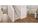 Inviting home entryway with hardwood floors, staircase, and kitchen view featuring stainless steel appliances at 321 Sound Cir, Stockbridge, GA 30281