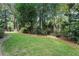 A leafy backyard featuring lush lawn, mature trees, and stepping stone pathway at 3609 Meadow Chase Dr, Marietta, GA 30062