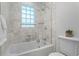 Bright bathroom featuring a tub/shower combination with glass door and tiled walls at 3609 Meadow Chase Dr, Marietta, GA 30062