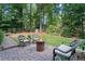 A brick patio seating area with a charming fire pit and lush green surroundings at 3609 Meadow Chase Dr, Marietta, GA 30062