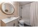 Well-lit bathroom with a white sink vanity, modern fixtures, round mirror, and a tub/shower combination with a white curtain at 361 Princeton Way, Lawrenceville, GA 30044