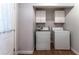 Practical laundry room with a washer, dryer, and upper cabinets for storage at 361 Princeton Way, Lawrenceville, GA 30044