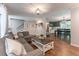 Open living room featuring a gray couch, hardwood floors, and an open floor plan to the dining room at 361 Princeton Way, Lawrenceville, GA 30044