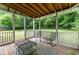 Relaxing screened porch featuring a wood ceiling and outdoor furniture surrounded by lush greenery at 361 Princeton Way, Lawrenceville, GA 30044
