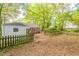 Landscaped backyard with partial fence and view of home's exterior, mature trees, and grass at 879 Sylvan Sw Pl, Atlanta, GA 30310