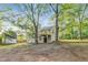 View of the backyard featuring a shed, deck, and mature trees providing shade and privacy at 733 Wesley Chapel Rd, Villa Rica, GA 30180