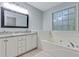 Bathroom with double vanity, granite countertop, soaking tub and a large window at 733 Wesley Chapel Rd, Villa Rica, GA 30180