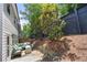 Comfortable backyard with a stone privacy wall, mulch bed and a cozy seating area with plush green cushions at 774 Belrose Dr, Smyrna, GA 30080
