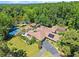 Aerial view of property featuring an in-ground pool, tennis court, multiple outbuildings and lush landscaping at 1572 Azalea Dr, Lawrenceville, GA 30043