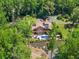 Stunning aerial view of a private home featuring an in-ground pool surrounded by lush landscaping and mature trees at 1572 Azalea Dr, Lawrenceville, GA 30043