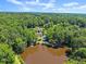Aerial view of the property featuring a pool, lake, surrounding by lots of mature trees at 1572 Azalea Dr, Lawrenceville, GA 30043