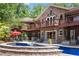 Beautiful backyard featuring a pool with stone trim, a covered patio, a gazebo, and mature landscaping at 1572 Azalea Dr, Lawrenceville, GA 30043
