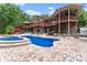 Stunning outdoor living area with a sparkling pool, spa, covered deck, and mature trees for shade at 1572 Azalea Dr, Lawrenceville, GA 30043