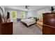 Bedroom features neutral paint, carpet, ceiling fan, and a piano in front of the windows at 1572 Azalea Dr, Lawrenceville, GA 30043