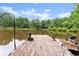 Wooden dock extending onto a tranquil lake, complete with fishing gear and seating at 1572 Azalea Dr, Lawrenceville, GA 30043