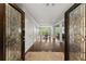 Elegant entryway featuring decorative glass double doors, hardwood floors, and a view into the formal dining room at 1572 Azalea Dr, Lawrenceville, GA 30043