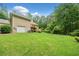 Large, grassy backyard with patio and stairs leading to a back entrance and attached garage at 2140 Old Orchard Lane Ln, Canton, GA 30114