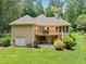 Back of house showing deck, patio, garage, and wooded lot at 2140 Old Orchard Lane Ln, Canton, GA 30114