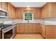 Well-lit kitchen featuring wooden cabinetry, stainless steel appliances, and durable granite countertops at 2140 Old Orchard Lane Ln, Canton, GA 30114