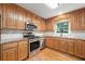 Well-lit kitchen featuring wooden cabinetry, stainless steel appliances, and durable granite countertops at 2140 Old Orchard Lane Ln, Canton, GA 30114