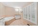 Spacious main bathroom with a soaking tub, granite countertops, and shuttered windows for natural light at 2140 Old Orchard Ln, Canton, GA 30114