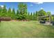 Expansive backyard featuring a well-manicured lawn and a charming pergola with outdoor dining area at 3015 Arbor Song Ct, Cumming, GA 30041