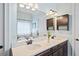 Bright bathroom featuring a double sink vanity with dark cabinets and quartz countertop at 3015 Arbor Song Ct, Cumming, GA 30041