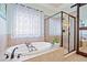 Bright bathroom showcasing a soaking tub, glass-enclosed shower, and neutral tile at 3015 Arbor Song Ct, Cumming, GA 30041