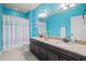 Bright blue bathroom with a double vanity, granite countertops, and shower-tub combo at 3015 Arbor Song Ct, Cumming, GA 30041