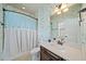 Cozy bathroom featuring bright wallpaper, modern vanity, and a tub-shower with patterned curtain at 3015 Arbor Song Ct, Cumming, GA 30041