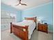 Cozy bedroom with a wooden bed frame, ceiling fan, and bright blue walls at 3015 Arbor Song Ct, Cumming, GA 30041