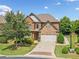 Charming two-story brick home with stone accents, a manicured lawn, and a two-car garage at 3015 Arbor Song Ct, Cumming, GA 30041