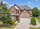 Beautiful brick and stone home with a well-maintained lawn, mature trees, and a two-car garage at 3015 Arbor Song Ct, Cumming, GA 30041
