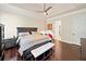 Spacious main bedroom featuring a dark wood bed frame, hardwood floors, and tray ceiling at 3015 Arbor Song Ct, Cumming, GA 30041
