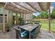 Outdoor patio featuring a large dining table beneath a retractable awning and verdant landscaping at 3015 Arbor Song Ct, Cumming, GA 30041