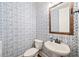 Stylish half bathroom with patterned wallpaper and pedestal sink at 3015 Arbor Song Ct, Cumming, GA 30041