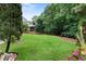 Expansive backyard with well-maintained lawn, mature trees, and partial fencing, offering a private and serene outdoor space at 32 Pullman Trl, Acworth, GA 30101